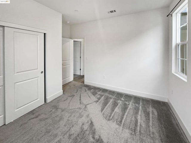 unfurnished bedroom with carpet flooring and a closet