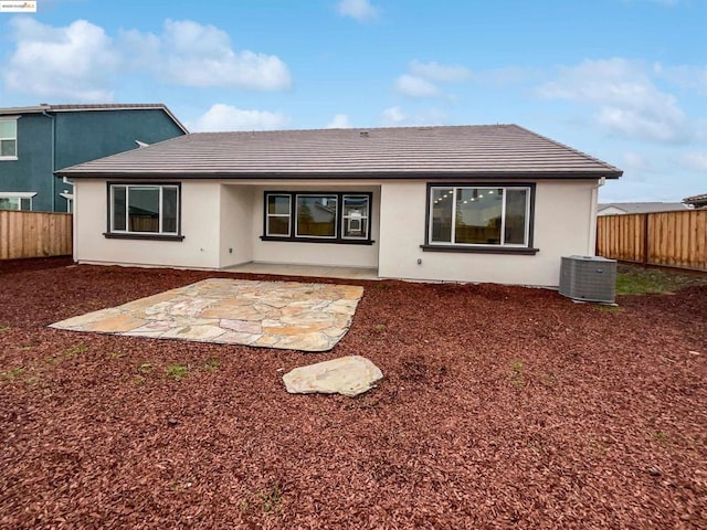 rear view of property featuring cooling unit and a patio area