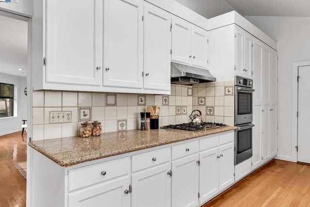 kitchen with white cabinets, decorative backsplash, light stone counters, stainless steel appliances, and light wood-type flooring