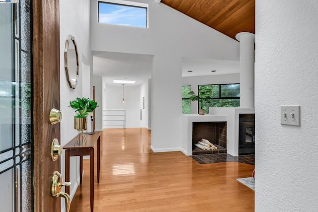 entryway with a healthy amount of sunlight, hardwood / wood-style floors, wooden ceiling, and high vaulted ceiling