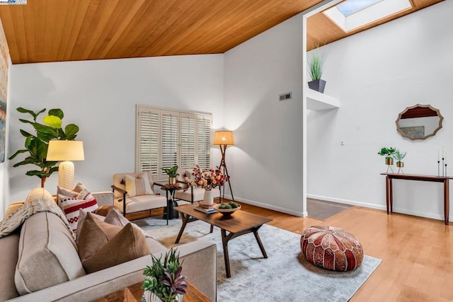 living room with vaulted ceiling with skylight, light hardwood / wood-style flooring, and wooden ceiling