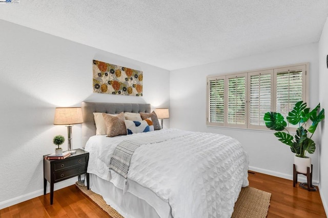 bedroom featuring hardwood / wood-style flooring and a textured ceiling