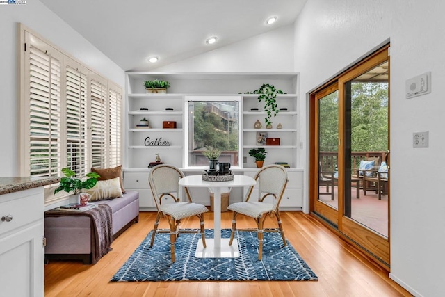 dining area with light hardwood / wood-style floors, vaulted ceiling, and built in features