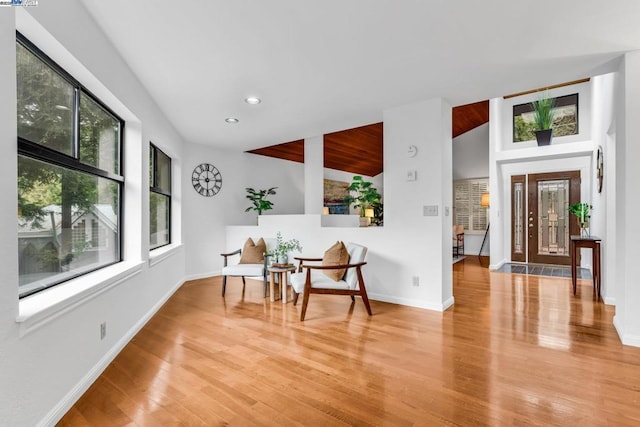 living area with lofted ceiling and hardwood / wood-style flooring