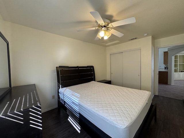 bedroom with ceiling fan, dark hardwood / wood-style flooring, and a closet