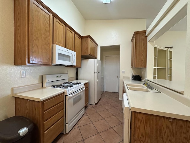 kitchen featuring sink, light tile patterned floors, and white appliances