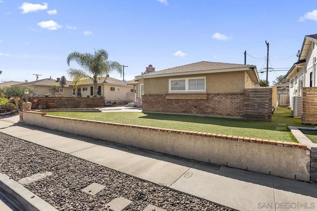 view of front of house featuring cooling unit and a front yard