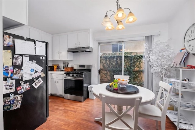 kitchen with white cabinetry, an inviting chandelier, hanging light fixtures, light hardwood / wood-style flooring, and stainless steel appliances