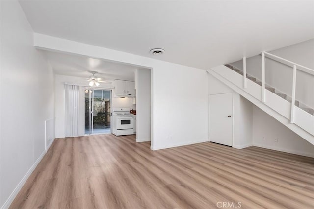 unfurnished living room featuring ceiling fan and light wood-type flooring