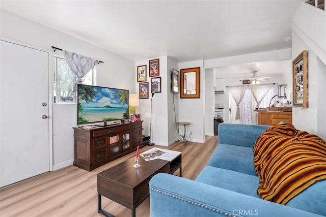 living room featuring ceiling fan and light hardwood / wood-style flooring