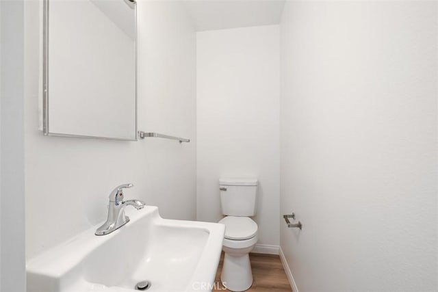 bathroom featuring sink, hardwood / wood-style floors, and toilet