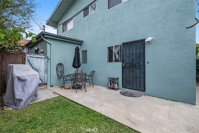 rear view of property with a patio and a lawn