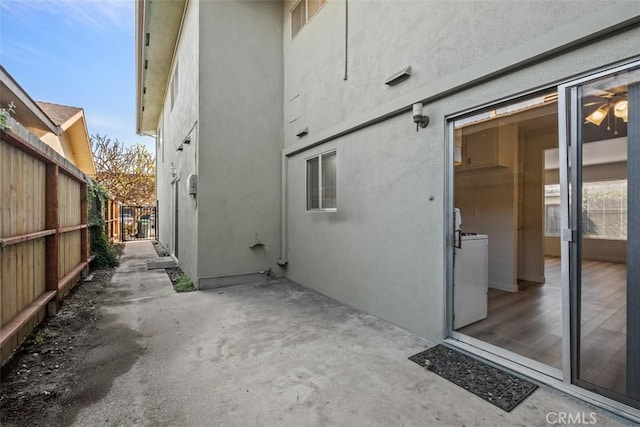 view of side of property with a patio and washer / dryer