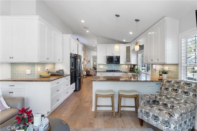 kitchen with pendant lighting, sink, white cabinets, kitchen peninsula, and stainless steel appliances