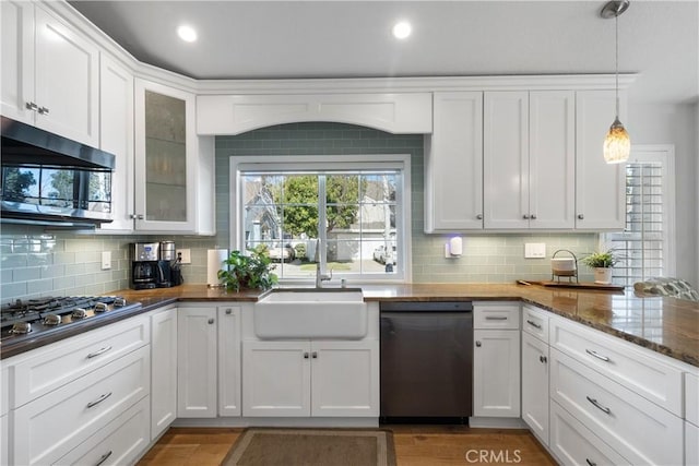 kitchen featuring sink, appliances with stainless steel finishes, hanging light fixtures, white cabinets, and dark stone counters