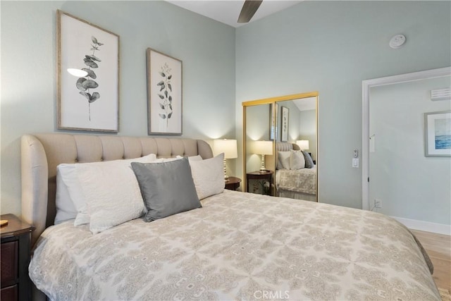 bedroom with hardwood / wood-style flooring, ceiling fan, and a closet