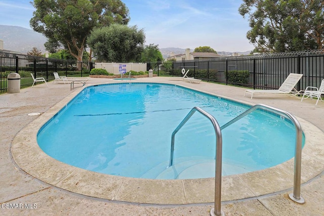 view of swimming pool with a patio and a mountain view