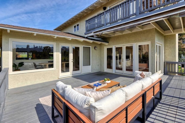 wooden terrace with an outdoor living space and french doors