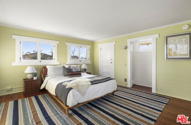 bedroom with ornamental molding, dark hardwood / wood-style floors, and multiple windows