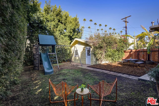 view of yard featuring a playground and a storage shed