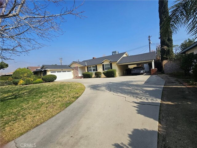 ranch-style house featuring a garage, a front yard, and a carport