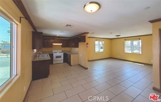 kitchen featuring light tile patterned flooring, sink, white range oven, crown molding, and dark brown cabinets