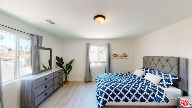 bedroom with multiple windows and light wood-type flooring