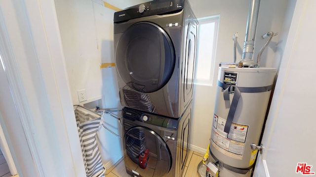 clothes washing area featuring stacked washer / drying machine and strapped water heater