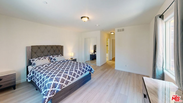 bedroom featuring multiple windows and light wood-type flooring