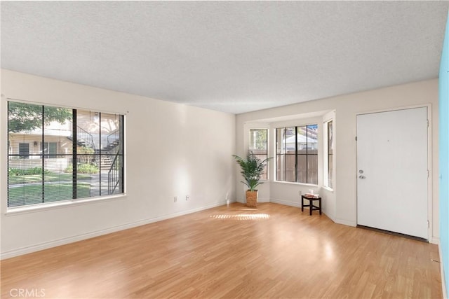 empty room featuring light hardwood / wood-style floors and a textured ceiling