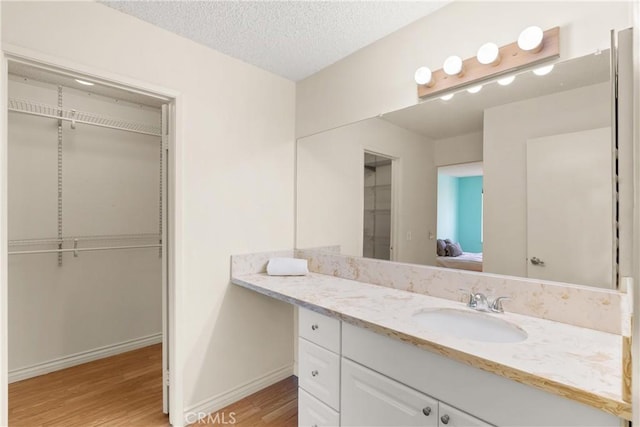 bathroom with vanity, hardwood / wood-style floors, and a textured ceiling