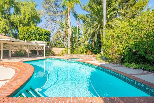 view of swimming pool with an in ground hot tub