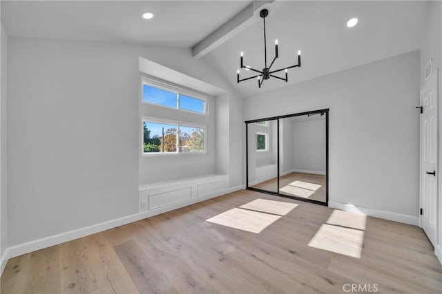 unfurnished bedroom with a closet, vaulted ceiling with beams, an inviting chandelier, and light hardwood / wood-style flooring