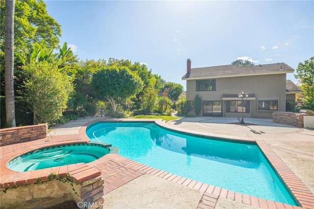 view of swimming pool featuring a patio and an in ground hot tub