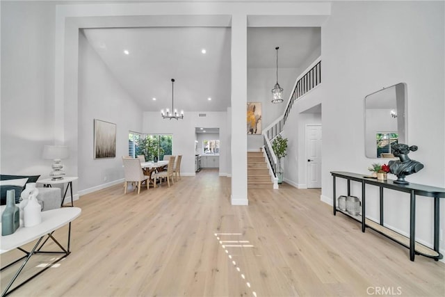 foyer featuring a high ceiling, a notable chandelier, and light hardwood / wood-style floors