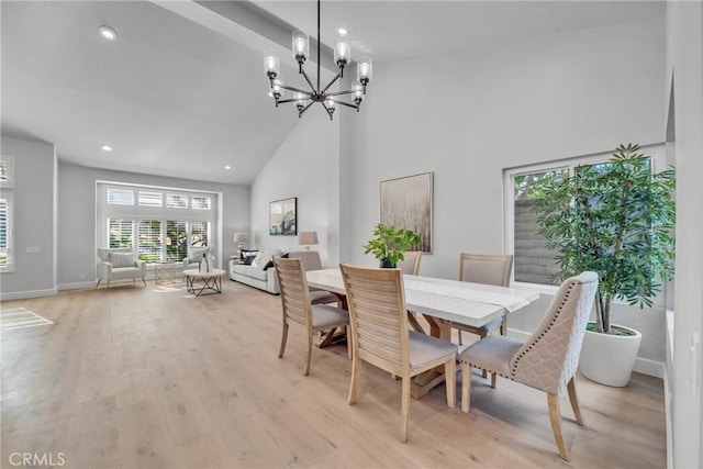 dining room featuring a notable chandelier, light hardwood / wood-style flooring, and high vaulted ceiling