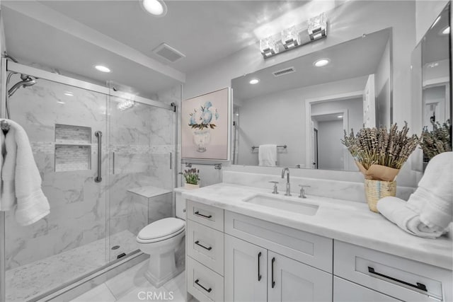 bathroom featuring vanity, a shower with shower door, and toilet