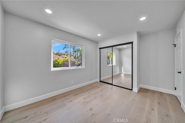 unfurnished bedroom featuring a closet and light hardwood / wood-style flooring