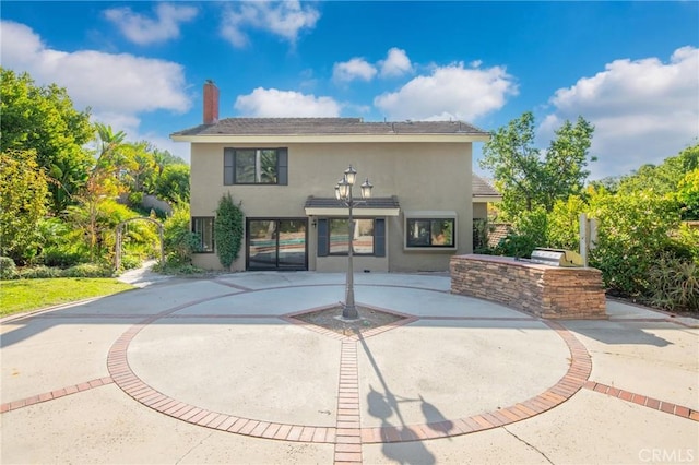 exterior space featuring a patio and an outdoor kitchen