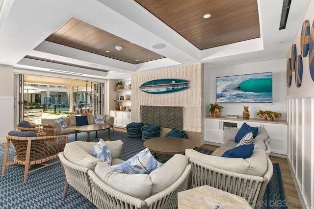 living room with hardwood / wood-style floors, a fireplace, wood ceiling, and a tray ceiling