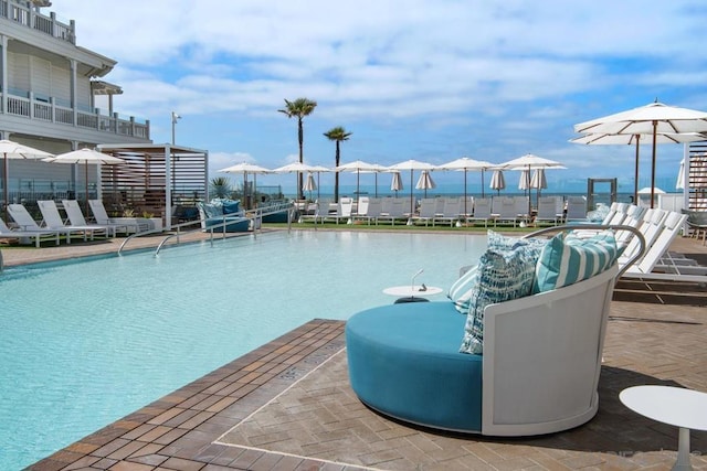 view of pool with a patio and a water view