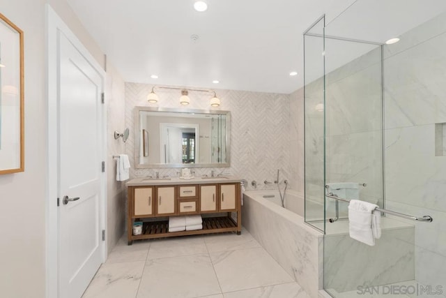 bathroom with vanity, tile walls, and separate shower and tub