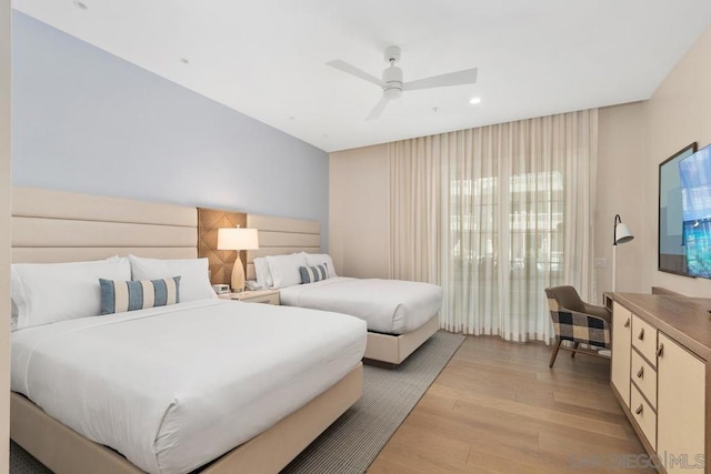 bedroom with multiple windows, ceiling fan, and light wood-type flooring