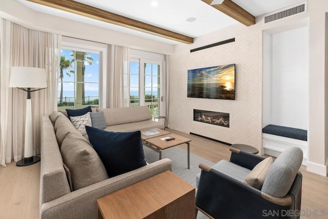 living room with beam ceiling and light wood-type flooring