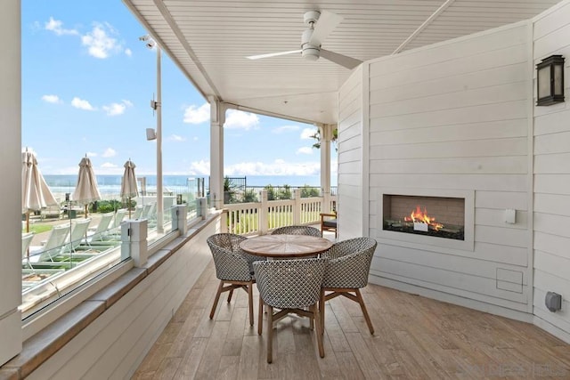 sunroom / solarium featuring exterior fireplace and ceiling fan