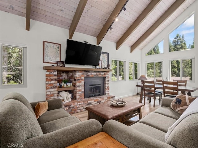 1153 Silvertip Ln, Fish Camp, CA 93623 - living room with a brick fireplace, beam ceiling, hardwood / wood-style floors, and high vaulted ceiling