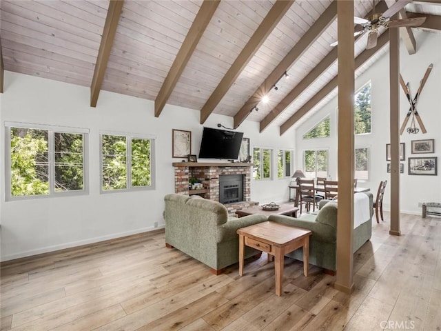 1153 Silvertip Ln, Fish Camp, CA 93623 - living room with beamed ceiling, a brick fireplace, high vaulted ceiling, and light hardwood / wood-style flooring