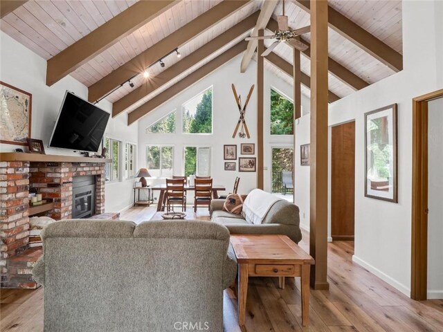 1153 Silvertip Ln, Fish Camp, CA 93623 - living room with wood ceiling, beam ceiling, high vaulted ceiling, a fireplace, and light wood-type flooring
