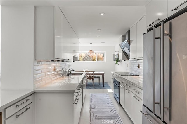 kitchen featuring white cabinetry, hanging light fixtures, black appliances, and sink