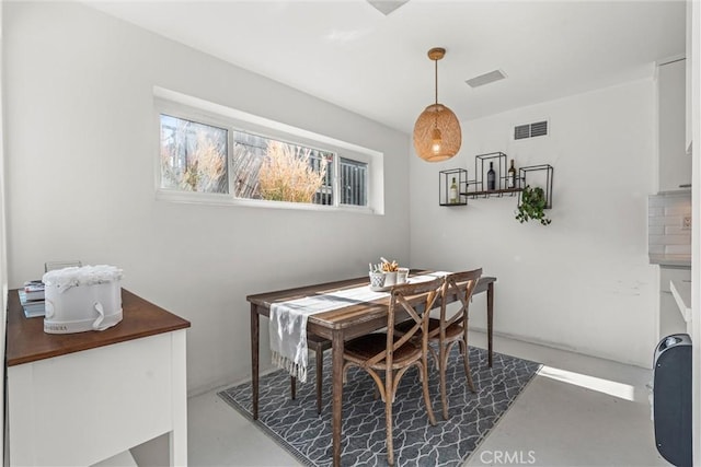 dining space featuring concrete floors